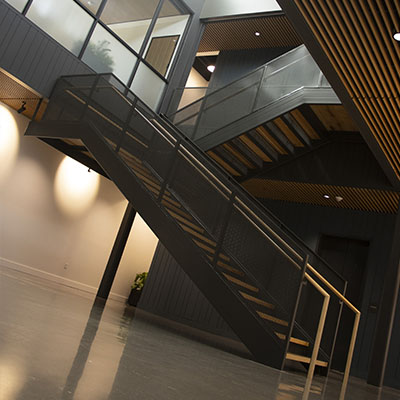 Modern interior with custom millwork stair installation, representing project closeout and final warranty coverage.