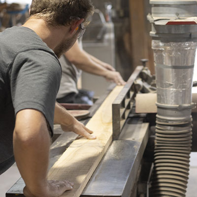 CbP Millworks craftsman shaping wood during the fabrication process, highlighting precision and durability.